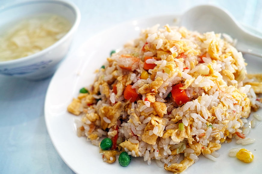 Close-up of delicious egg fried rice with vegetables on a white plate
