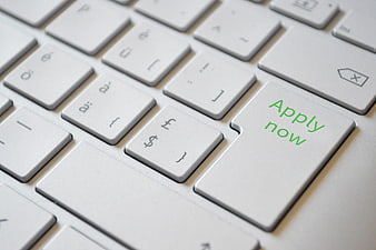 Close-up of laptop keyboard with green apply now button