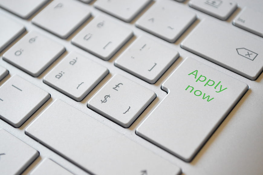 Close-up of laptop keyboard with green apply now button