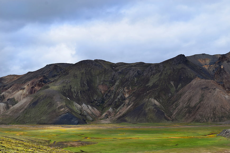 Dramatic Icelandic Highland Landscape with Green Valley and Cloudy Sky