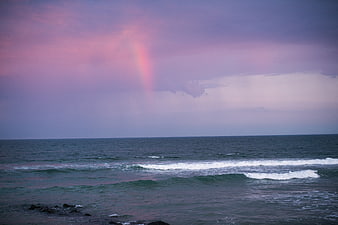 Pink Rainbow Over Ocean Waves at Dusk