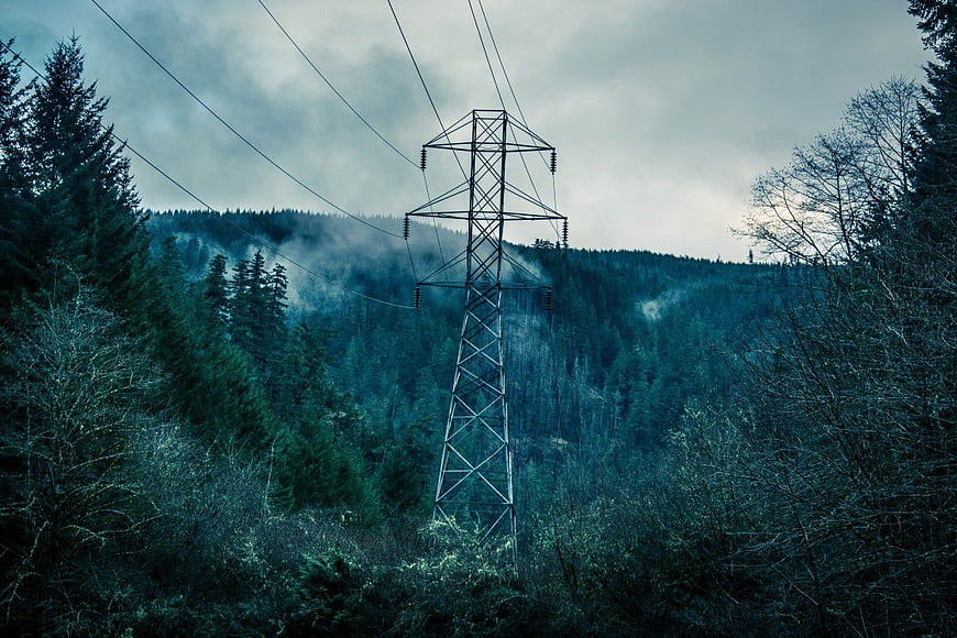 High Voltage Power Line Tower in Misty Forest