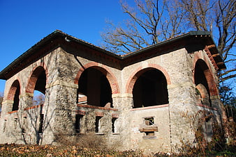 Historic stone mill building with brick arches in Monza park