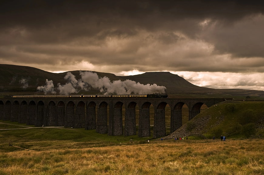 Steam train crossing Glenfinnan Viaduct in Scottish Highlands
