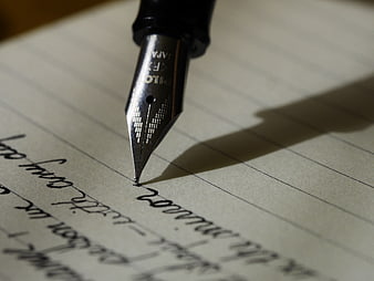 Close-up of fountain pen nib writing on lined paper