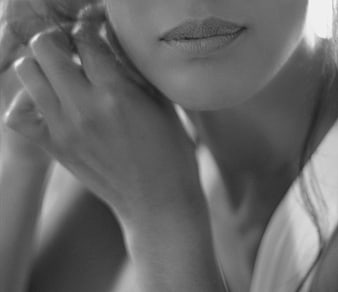 Black and white close-up of a woman's lips and hand