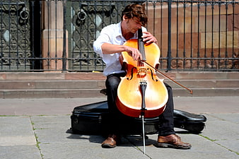 Male Cellist Playing Cello on Street in Sunlight