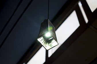 Modern perforated metal pendant light fixture hanging from ceiling