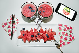 Flat lay of star-shaped watermelon slices and berry smoothies