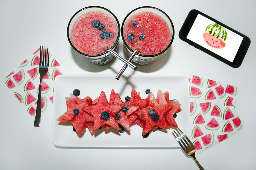 Flat lay of star-shaped watermelon slices and berry smoothies