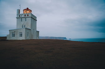 White Lighthouse on Cliff Overlooking Ocean at Dusk