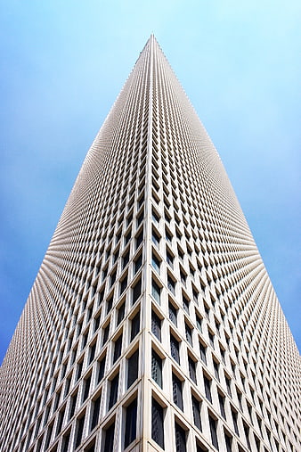 Low angle view of tall skyscraper against blue sky