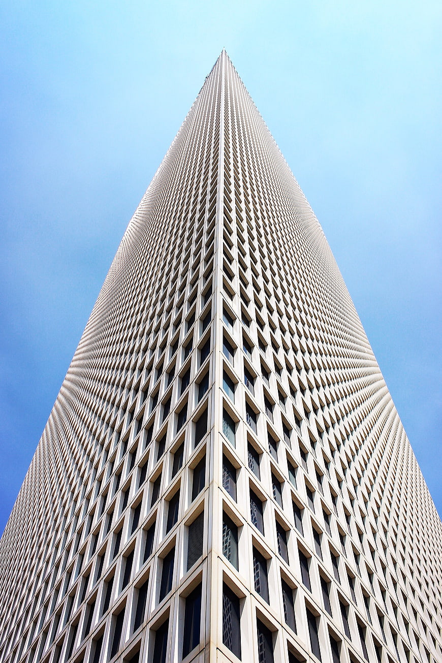 Low angle view of tall skyscraper against blue sky