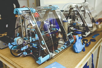 Blue 3D Printer On Workbench With Printed Models