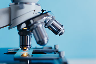 Close-up of microscope objective lenses on a blue background