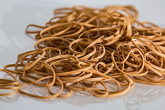 Pile of brown rubber bands on white background