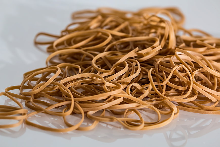 Pile of brown rubber bands on white background