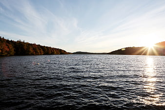 Sunset over a lake with autumn trees and blue sky