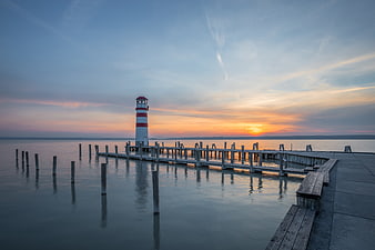 Serene Lighthouse on Wooden Pier at Sunset