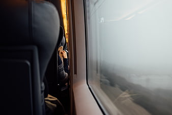 Passenger reading book on train window seat