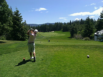 Golfer Swinging Club on Sunny Green Course