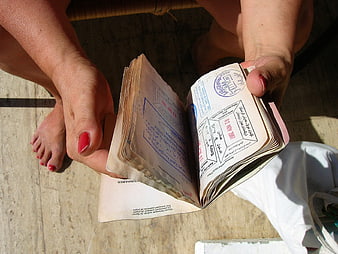 Woman holding open passport with visa stamps