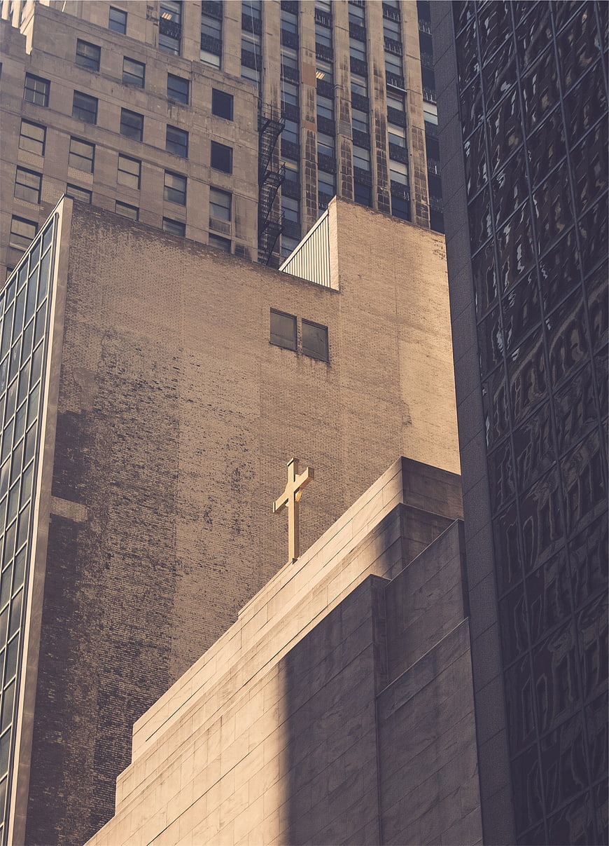 Golden Cross on Urban Church Building Amidst Skyscrapers