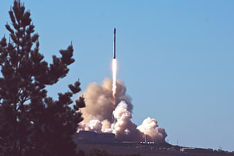 Rocket Launch with Smoke Trail and Pine Tree Foreground