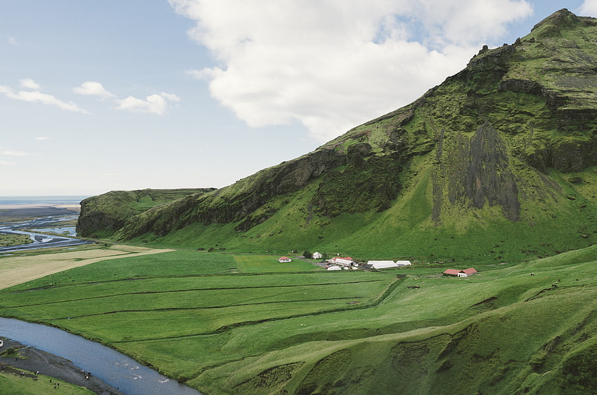 Scenic Icelandic Valley with Green Hills and Farmhouses