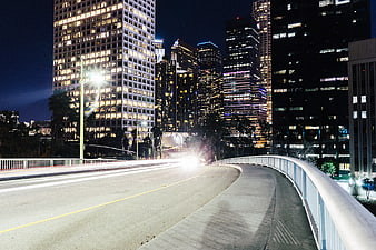 Night cityscape with light trails on a bridge