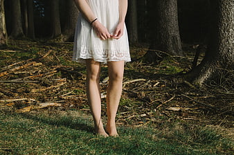 Woman in White Dress Standing Barefoot in Forest