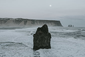 Dramatic coastal landscape with sea stack and cliffs under moonlight