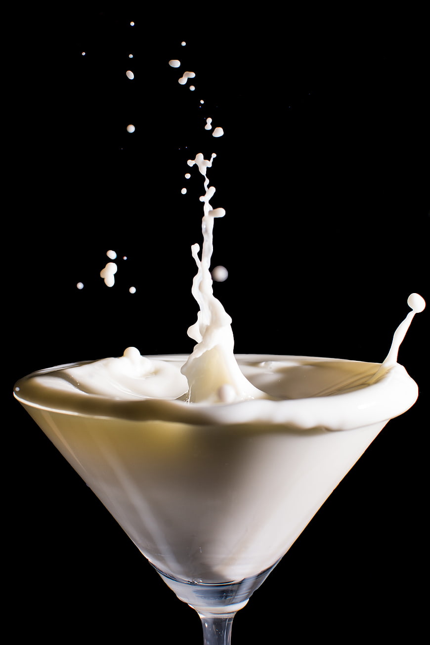 Milk Splash in Martini Glass on Black Background