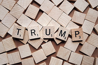 Trump spelled with wooden Scrabble tiles on background