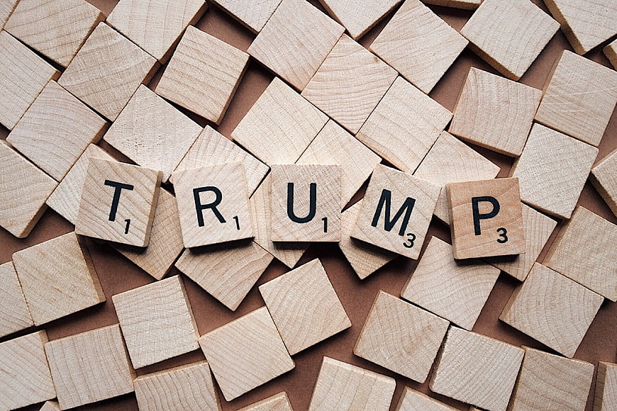 Trump spelled with wooden Scrabble tiles on background