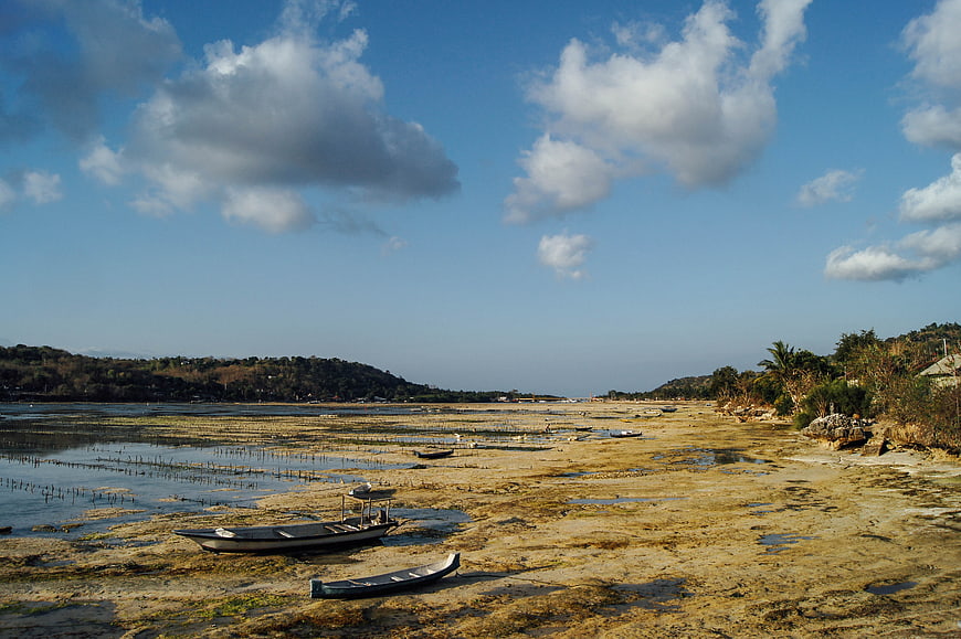 Fishing boats resting on mudflats at low tide coastal landscape