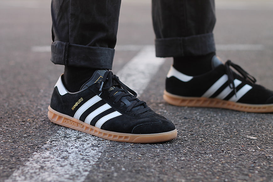 Close-up of black Adidas Hamburg sneakers on asphalt