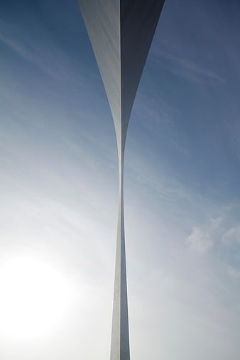 Low angle view of modern twisted skyscraper against blue sky