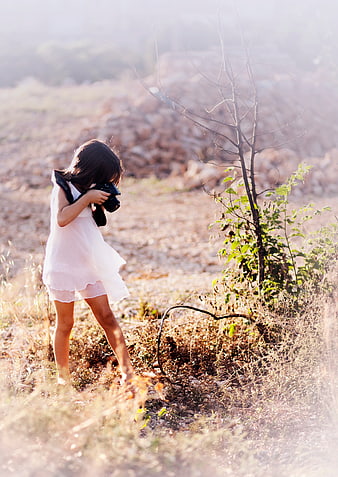 Little Girl Photographer Taking Pictures in a Sunny Field