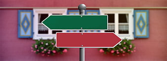 Blank Red and Green Directional Signpost in Front of Pink House