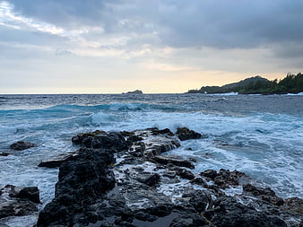 Dramatic Ocean Waves Crashing on Rocky Coastline at Dusk