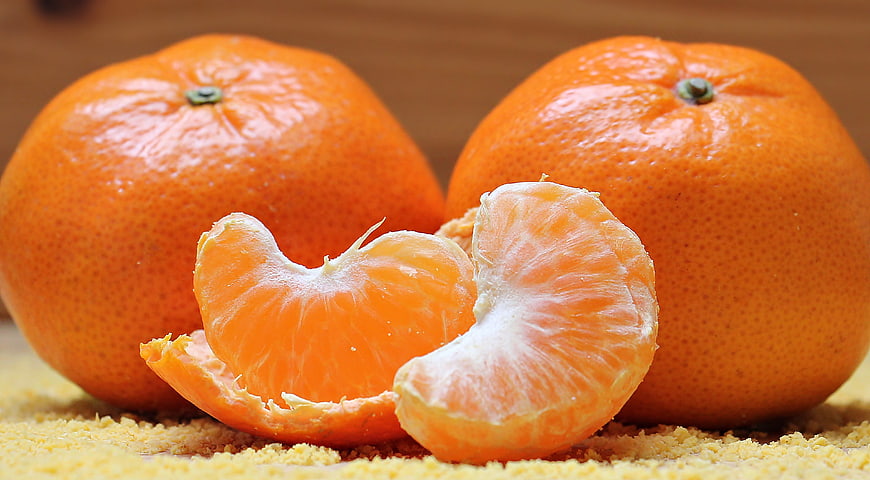 Fresh peeled tangerine segments with whole citrus fruit