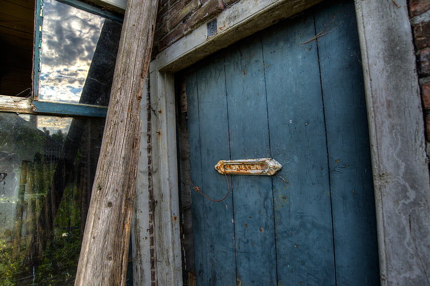 Weathered Blue Wooden Door with Rusty Mail Slot
