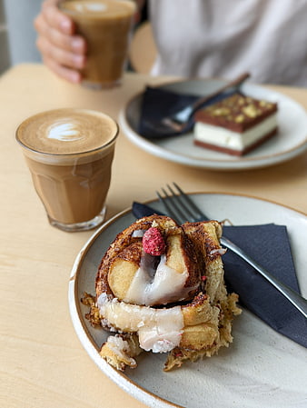 Cinnamon bun with apple and coffee in a cozy cafe