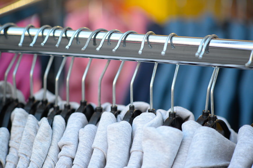 Gray sweatshirts on metal hangers in clothing store