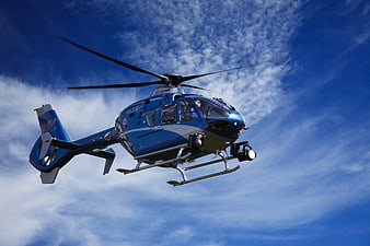 Blue Police Helicopter Flying in Blue Sky