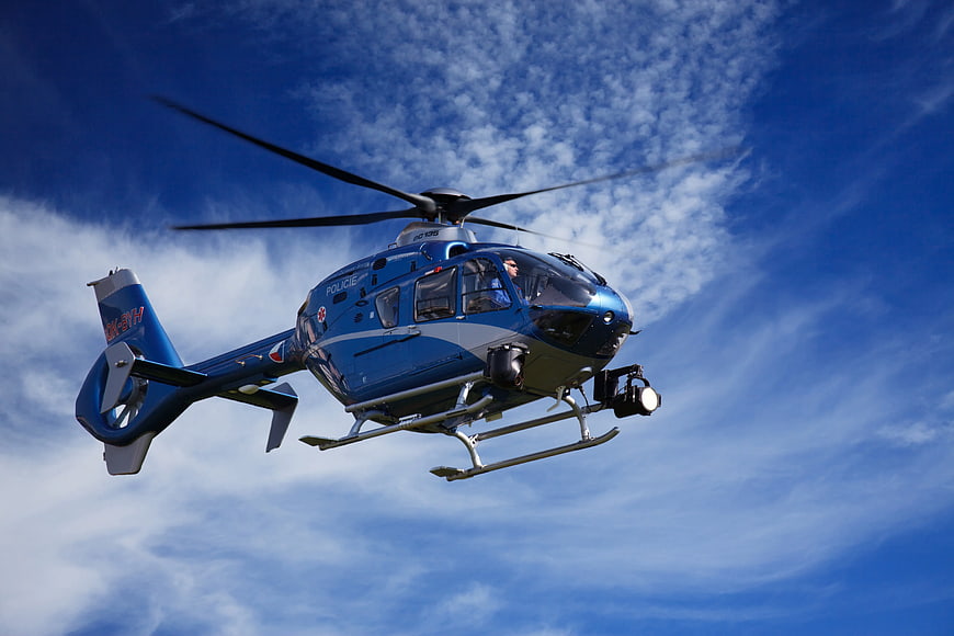 Blue Police Helicopter Flying in Blue Sky