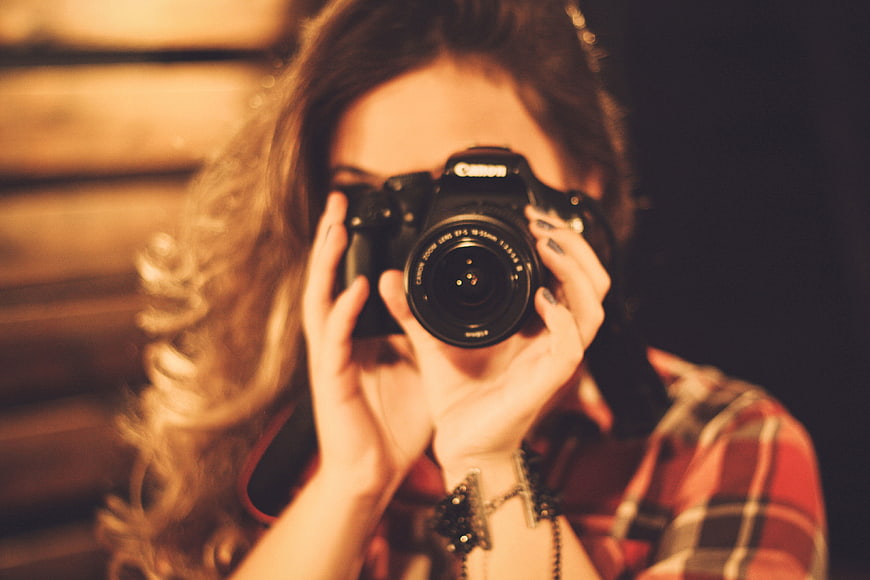 Woman Photographer Holding DSLR Camera to Eye