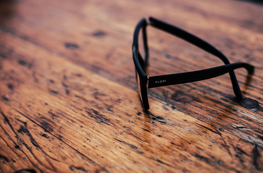 Black Gucci Sunglasses on Rustic Wooden Table