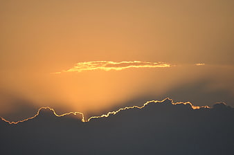 Golden Sunset Rays Illuminating Cloud Silhouette